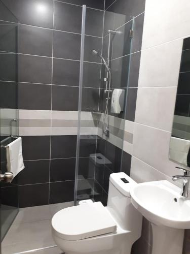 a bathroom with a toilet and a sink at Hotin Inn in Kuching