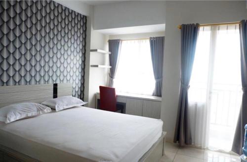 a bedroom with a white bed and a window at Sartika Apartment Margonda Residence 2 in Parungmalela