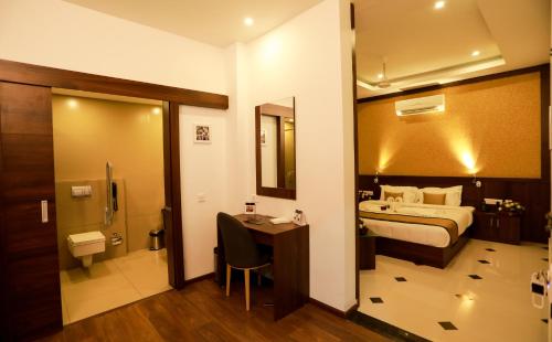 a hotel room with a bed and a bathroom at Hotel Emperor in Kannur