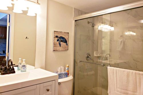 a bathroom with a shower with a glass shower backdoor at Pirates Cove Condo Unit #704 in Daytona Beach Shores
