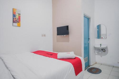 Habitación blanca con cama y lavamanos en RedDoorz near Jalan Soeprapto Bengkulu, en Bengkulu