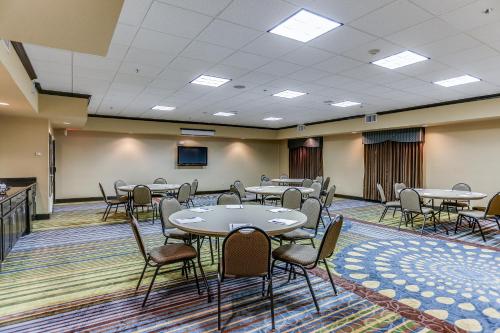 a conference room with tables and chairs and a tv at Holiday Inn Express Hotel & Suites Huntsville by IHG in Huntsville