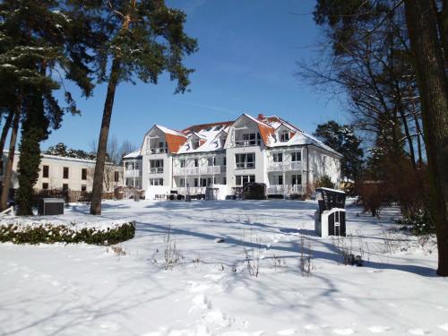 a large white house with snow on the ground at Victoria Suites in Bad Saarow