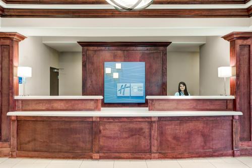 a woman standing behind a counter in a lobby at Holiday Inn Express & Suites Raceland - Highway 90 by IHG in Raceland