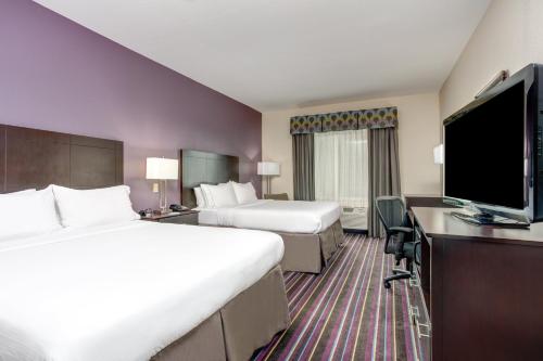a hotel room with two beds and a flat screen tv at Holiday Inn Express & Suites Raceland - Highway 90 by IHG in Raceland