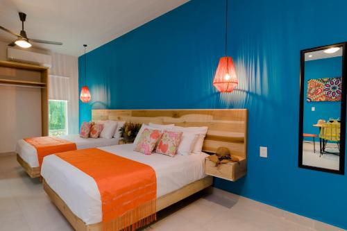 - une chambre avec 2 lits et un mur bleu dans l'établissement Riviera Sayulita Hotel, à Sayulita