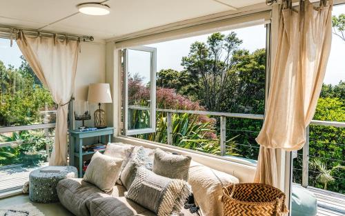 a living room with a couch and a large window at Waiheke Island Motel in Ostend
