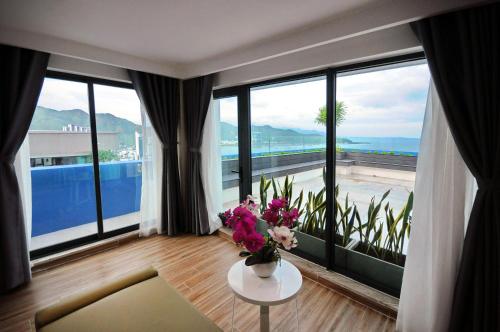 a living room with a table with flowers on it at Anrizon Hotel Nha Trang in Nha Trang