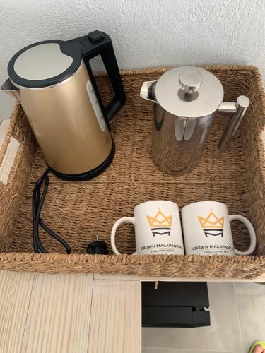 a coffee pot and two coffee cups on a shelf at Crown Malapascua in Malapascua Island