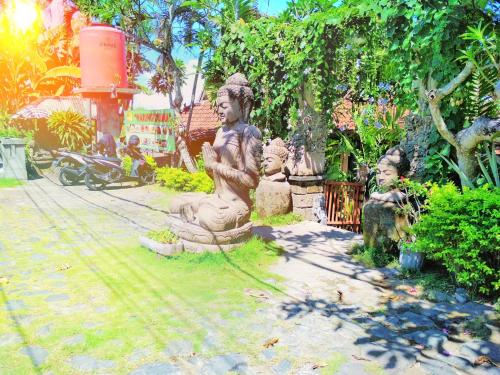 a group of statues sitting in a garden at Bali Eco Living Yoga Healing Meditation and Retreat Center in Denpasar