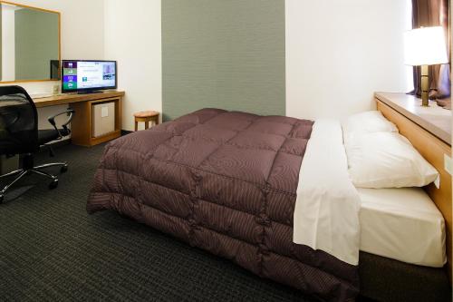 a hotel room with a bed and a desk with a computer at Gifu Washington Hotel Plaza in Gifu