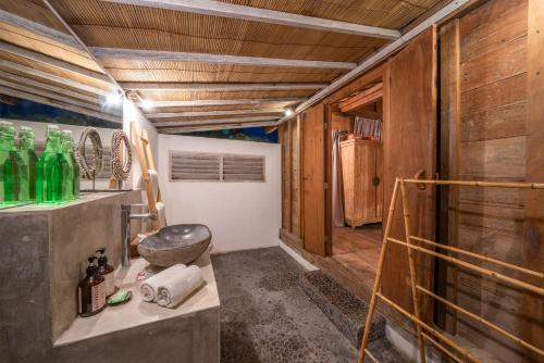 een badkamer met houten wanden en een aanrecht met groene flessen bij Villa Palm Tree - Huge 4bd Villa CENTER SEMINYAK in Seminyak