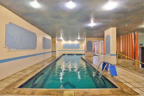 a indoor swimming pool with blue water in a building at Al-faleh Hotel in Al Baha