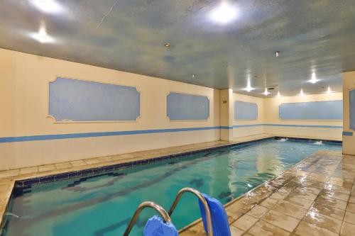 a swimming pool with blue water in a building at فندق الفالح للوحدات الفندقيه in Al Baha