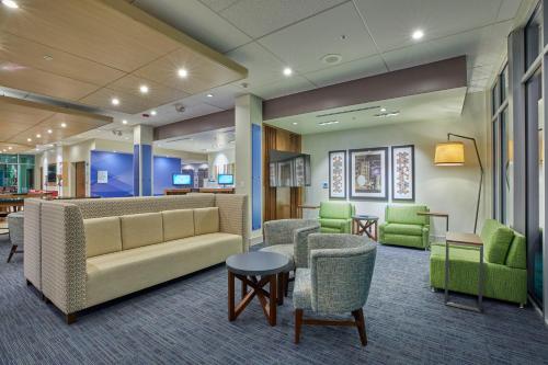 a lobby with a couch and chairs and tables at Holiday Inn Express & Suites - Hermiston Downtown by IHG in Hermiston