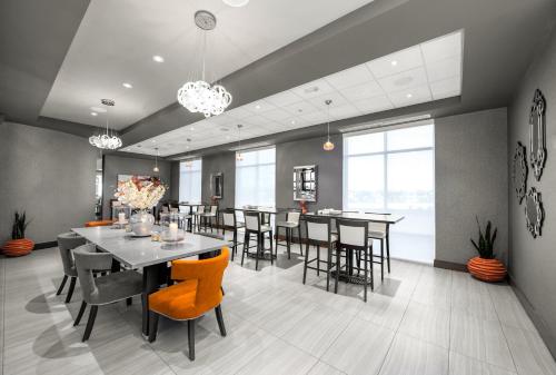a dining room with tables and chairs and windows at Holiday Inn Hotel & Suites Davenport by IHG in Davenport
