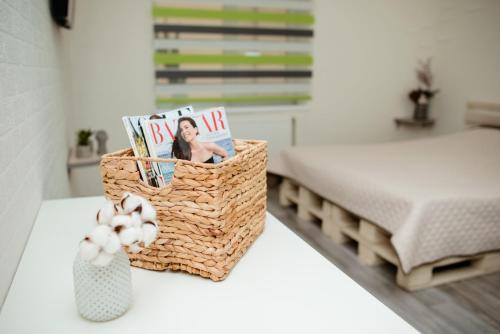 a table topped with a basket with magazines and a vase at Apartments at Kontorska 10 in Kharkiv