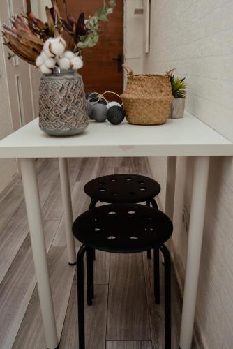 a white table with a stool and a vase with flowers at Apartments at Kontorska 10 in Kharkiv