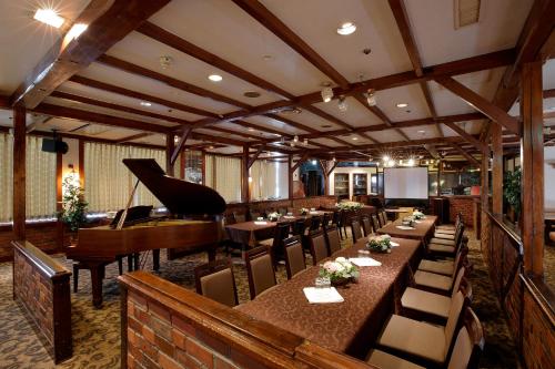 a restaurant with a piano and tables and chairs at Gifu Washington Hotel Plaza in Gifu