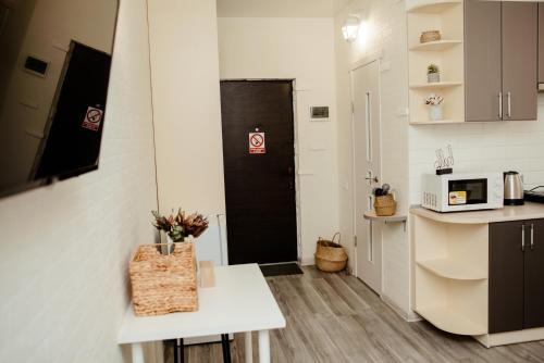 a small kitchen with a white table and a black door at Apartments at Kontorska 10 in Kharkiv