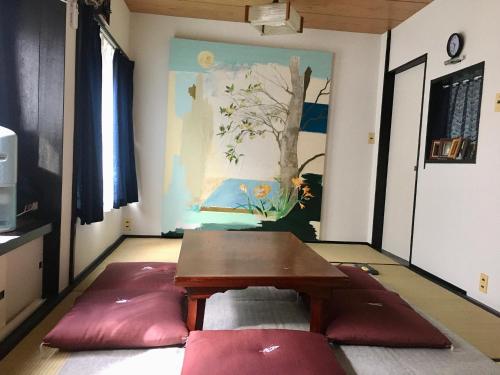 a room with a table and a painting on the wall at Oasis Wadaura in Minamiboso