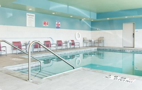 una piscina con sillas y mesas en un edificio en Holiday Inn Express & Suites Rock Falls, an IHG Hotel, en Rock Falls