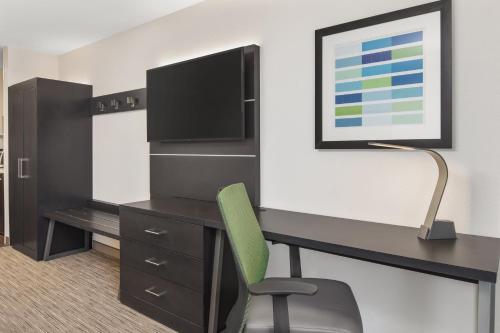 a room with a desk with a tv and a chair at Holiday Inn Express Hotels & Suites Greenville-Spartanburg/Duncan by IHG in Duncan