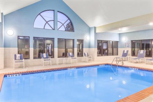a pool in a hotel with chairs around it at Holiday Inn Express Hotels & Suites Greenville-Spartanburg/Duncan by IHG in Duncan