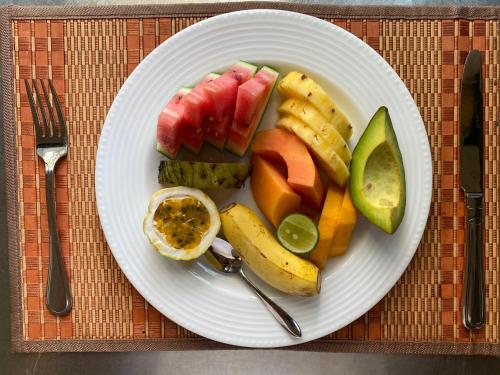 a white plate with fruits and vegetables on a table at Sujeewani Villa in Negombo