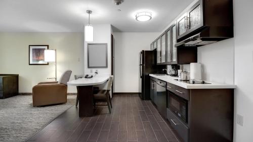 a kitchen with a counter and a sink and a table at Candlewood Suites Waco by IHG in Waco