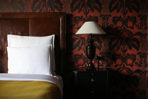 a bedroom with a bed and a lamp on a night stand at Rooms Hotel Tbilisi in Tbilisi City