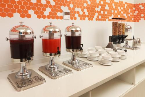 a counter with two coffee machines and cups on it at Holiday Inn Express & Suites - Ensenada Centro by IHG in Ensenada