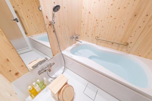 een badkamer met een bad en een douche bij 至誠宿 SHISEI-JUKU Omiya-Gojo in Kyoto