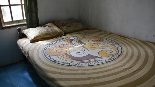 Bett mit Design in einem Zimmer in der Unterkunft Sri Homestay in Sermo