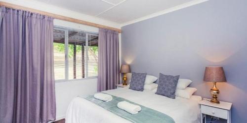 um quarto com uma cama grande e uma janela em Konings Cottage em Gansbaai