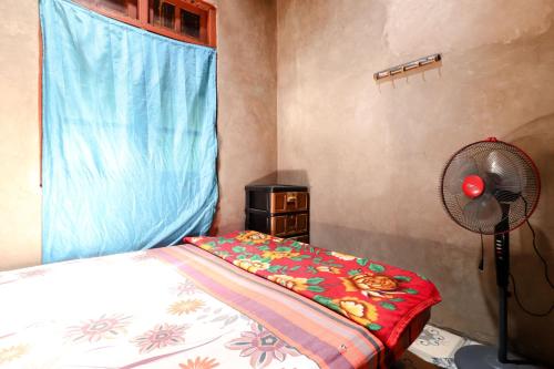 a bedroom with a bed and a fan and a window at Iran Homestay in Sermo