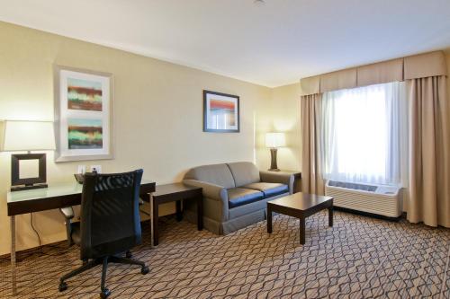 a hotel room with a desk and a chair at Wingate by Wyndham Fort Saskatchewan in Fort Saskatchewan