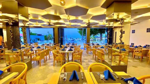 Kaani Palm Beach في مافوشي: مطعم به طاولات وكراسي ومطل على المحيط
