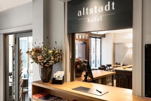 un restaurante con un jarrón de flores sobre una mesa en Altstadt Hotel, en Zúrich