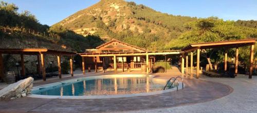a resort with a pool with a mountain in the background at Agriturismo Tenute Pispisa Segesta in Calatafimi