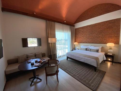 a bedroom with a bed and a table in a room at Marasa Sarovar Premiere, Bodhgaya in Bodh Gaya