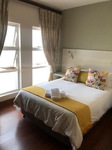 a bedroom with a large bed with two pillows at 314 on Clark Guest House in Pretoria