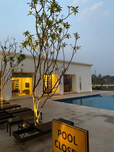 a pool closed sign next to a tree next to a building at Marasa Sarovar Premiere, Bodhgaya in Bodh Gaya