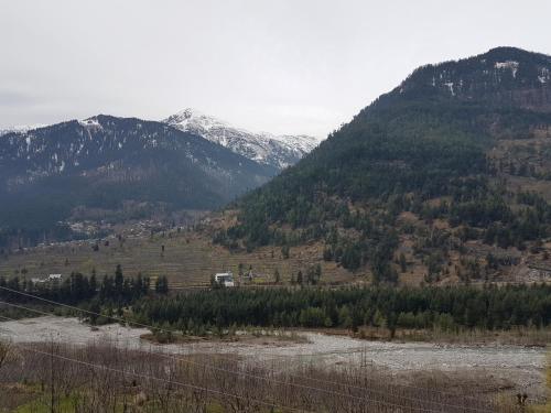 a view of a mountain with snow capped mountains at Sunface Homestay in Manāli