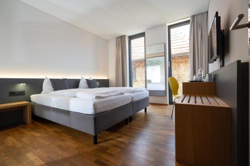 um quarto com uma cama grande e uma televisão em Gasthaus zur Sonne em Nordheim