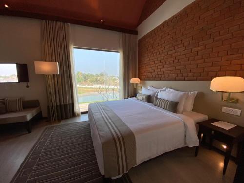 a hotel room with a bed and a brick wall at Marasa Sarovar Premiere, Bodhgaya in Bodh Gaya