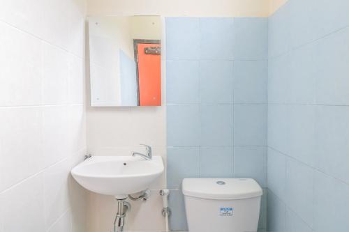 a white bathroom with a sink and a toilet at Catur Adi Putra in Denpasar