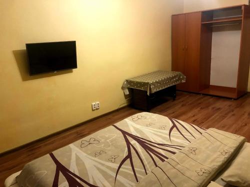 a room with a bed and a tv on a wall at GIL Apartments, Lermontova 1a, centre in Uzhhorod