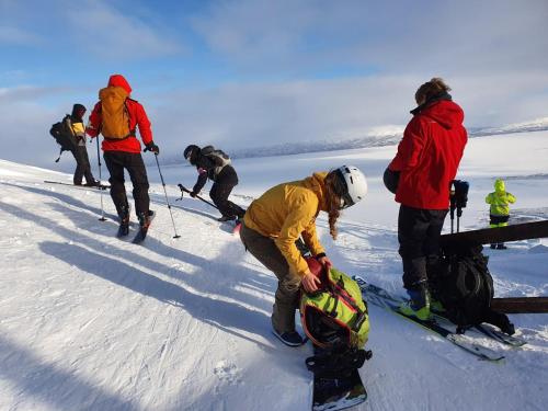 people riding skis on top of a snow covered slope at STF Abisko Turiststation in Abisko