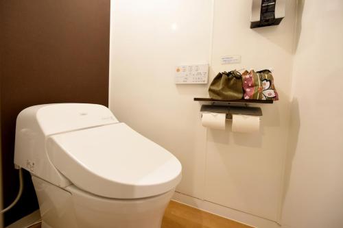 a white toilet in a bathroom with a purse at Awakan in Sumoto